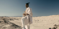 Christian Scott mit Trompete in der Wüste